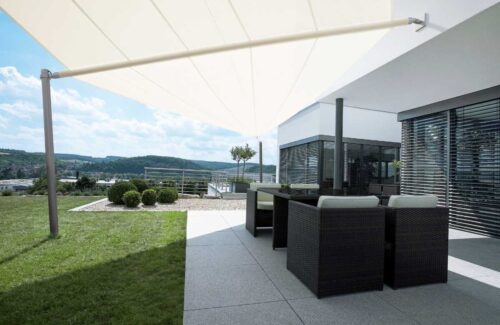 Weißes Sonnensegel über dem Outdoor-Bereich eines Hauses