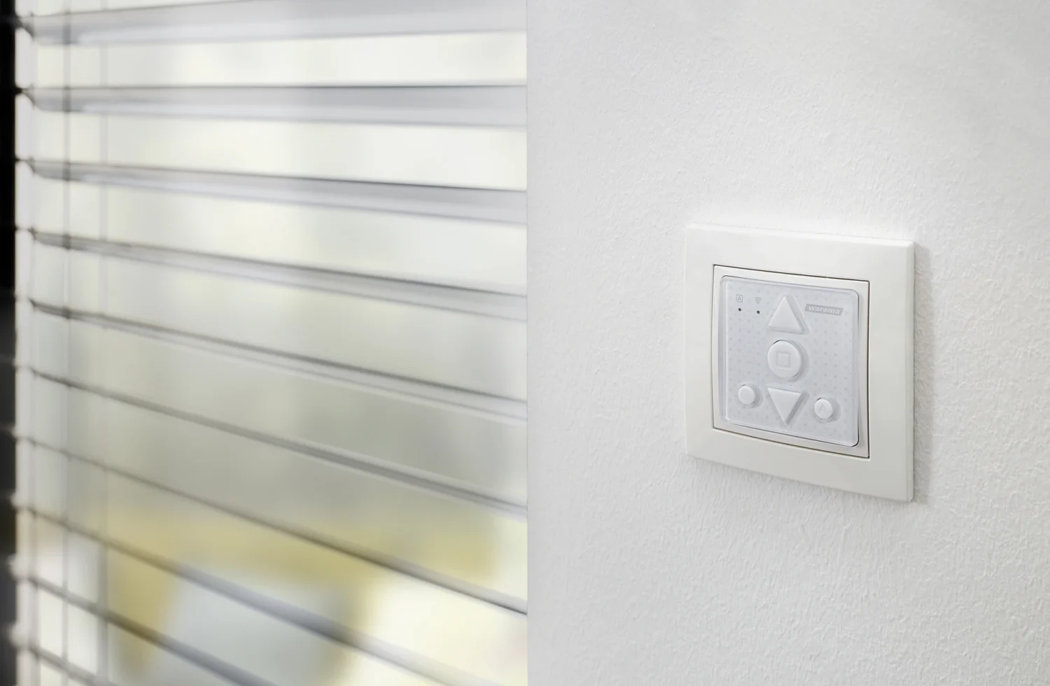 Jalousiensteuerung an der Wand neben modernen Lamellen