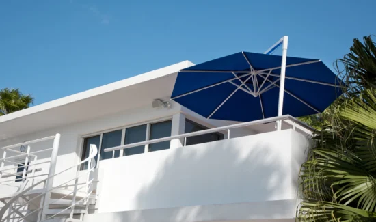 Moderne Villa mit blauem Sonnenschirm auf dem Balkon